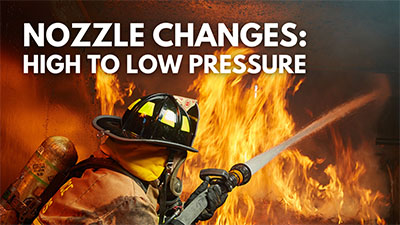 A firefighter uses a nozzle to battle flames